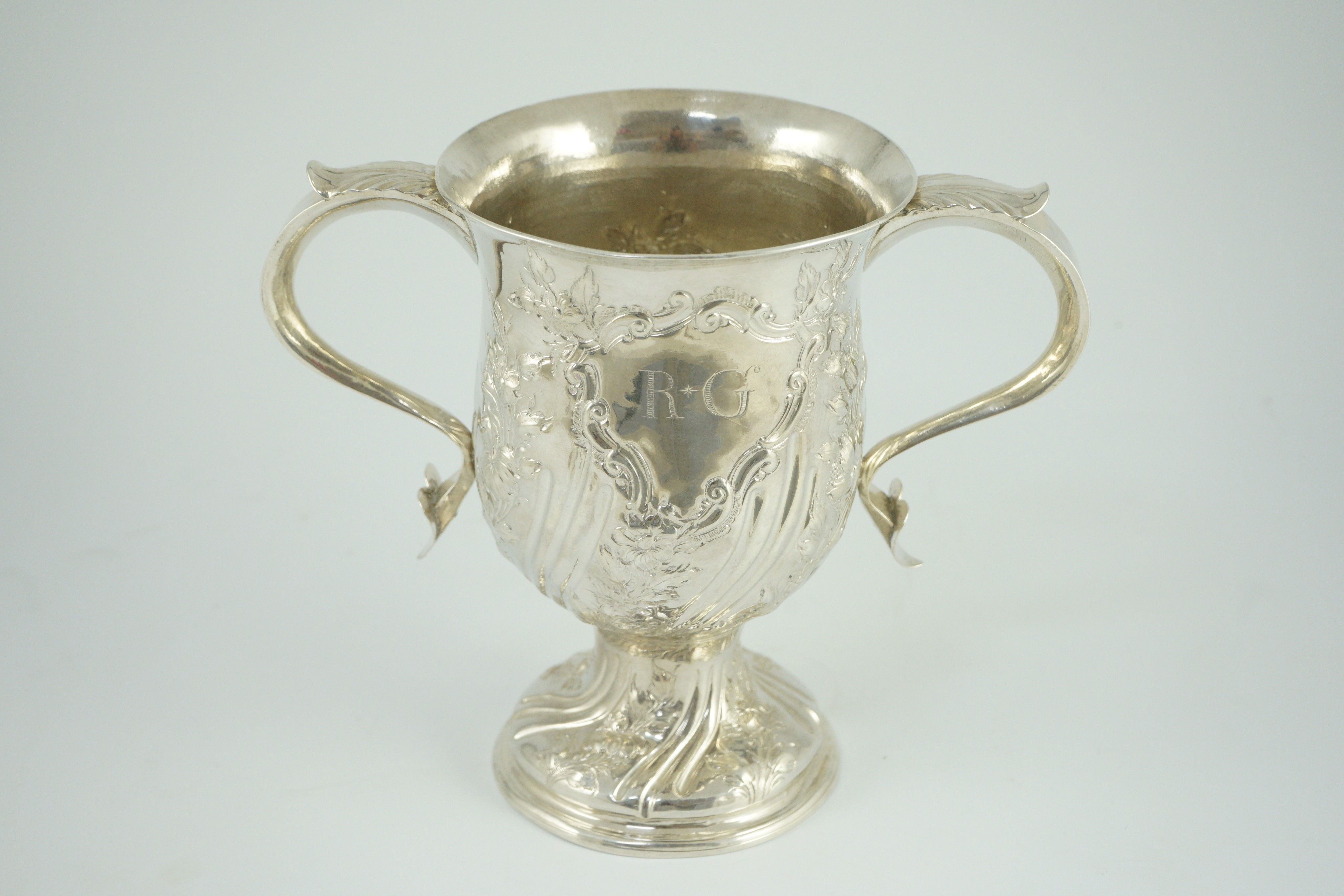 A George III silver baluster two handled pedestal cup, with later embossed decoration, by John Scofield